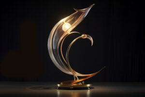 A modern artistic glass table lamp with elegant curved shapes, warm golden light, and a sculptural design set against a dark background.